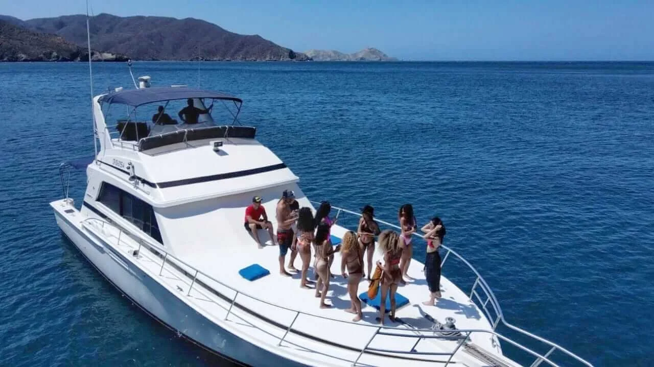 Grupo de personas disfrutando a bordo de un yate de lujo en Santa Marta con vista al mar Caribe.